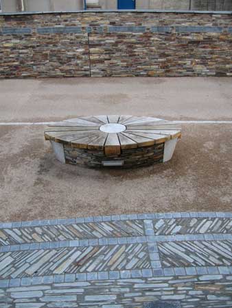 Detail in Trevena Square, Tintagel, 2005: Wall of words.  Words: Amanda White; Seat designed by Michael Fairfax and fabricated in oak by Alistair Guy; granite, De Lank Quarry; slate, Costains. Artist and photographer, Michael Fairfax.